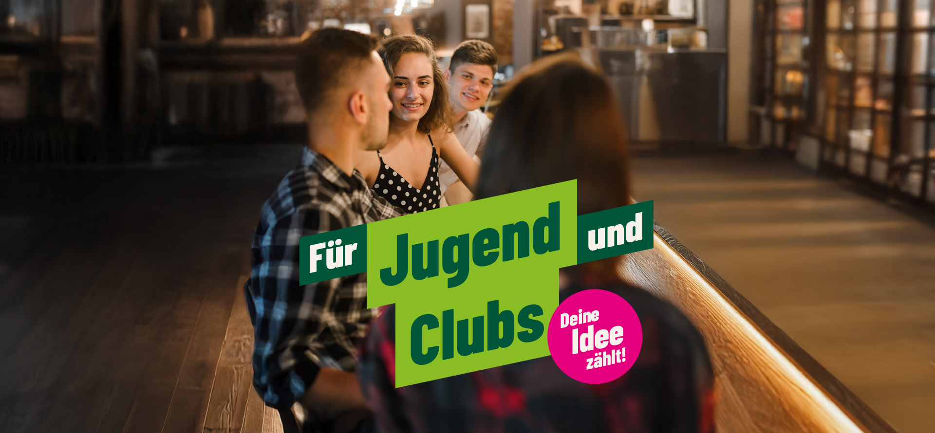 4 junge Menschen stehen an einer Bar und unterhalten sich. Text: "Für Jugend und Clubs", im pinken Kreis: "Deine Idee zählt"