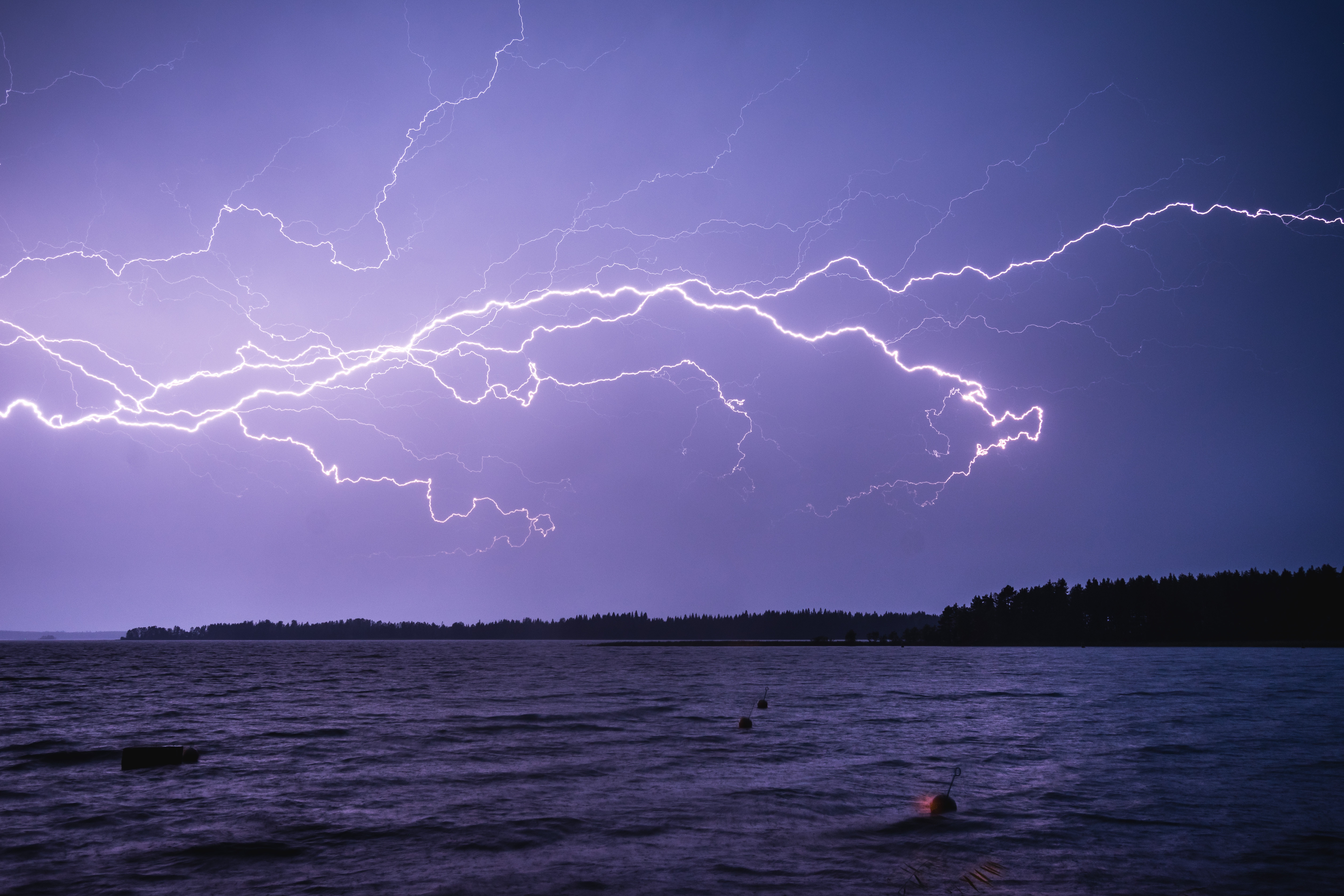 Blitzeinschlag über einem See. Unwetter und Extremwetterereignisse werden im Zuge der Klimakrise zunehmen.