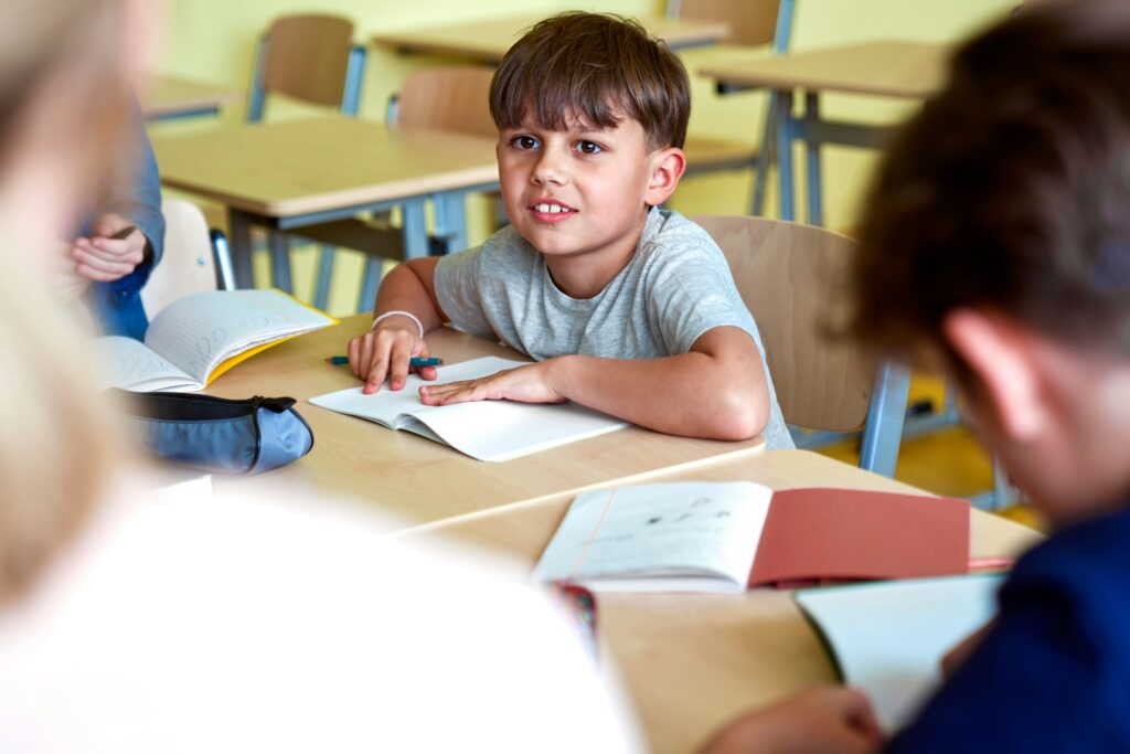 Junge sitzt in einem Klassenzimmer