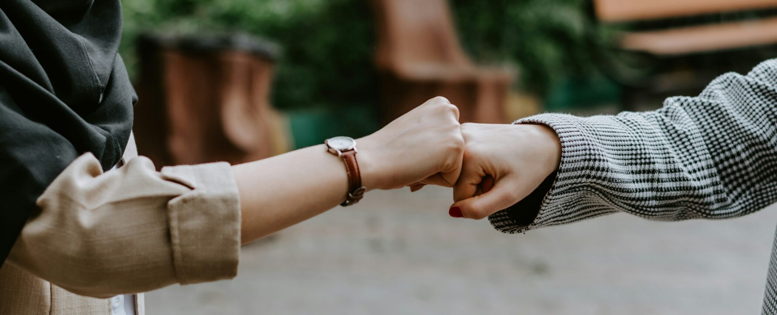 Zwei Menschen begrüßen sich, indem sie die Fäuste aneinander drücken.