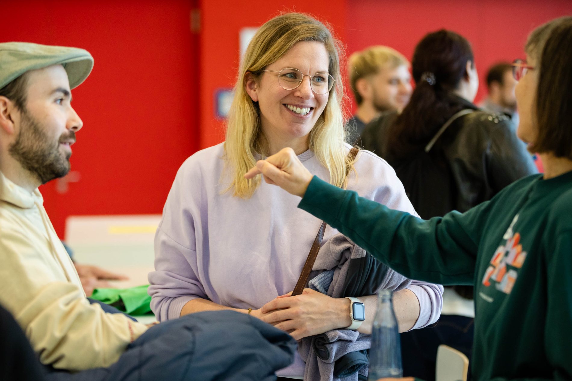 Drei menschen stehen und sprechen miteinander.