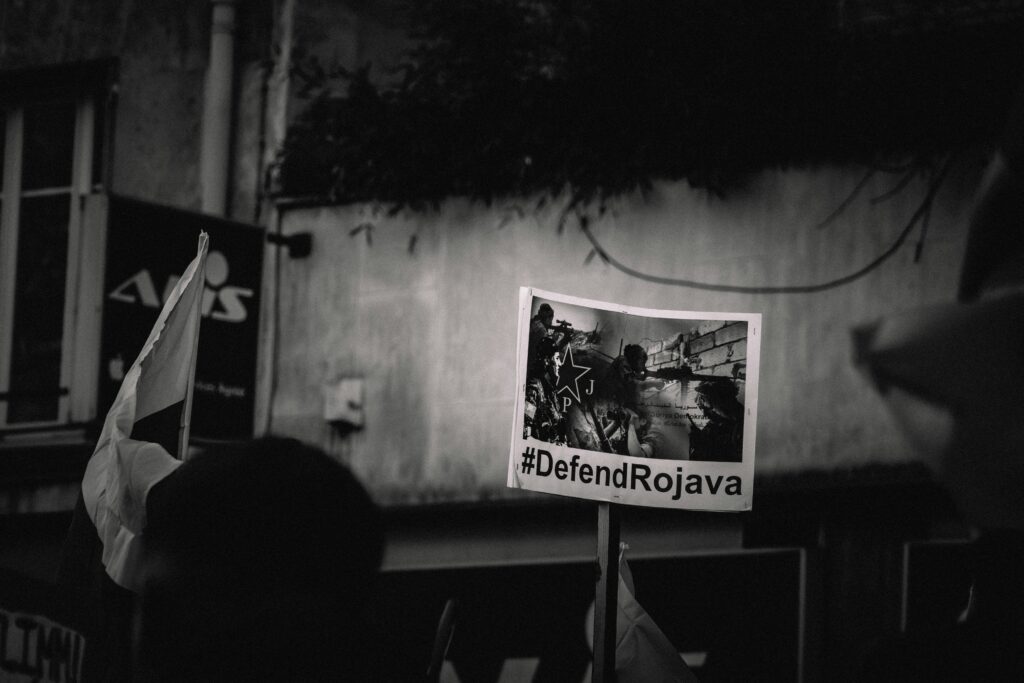 Schild auf Demo mit der Aufschrift "#Defend Rojava"