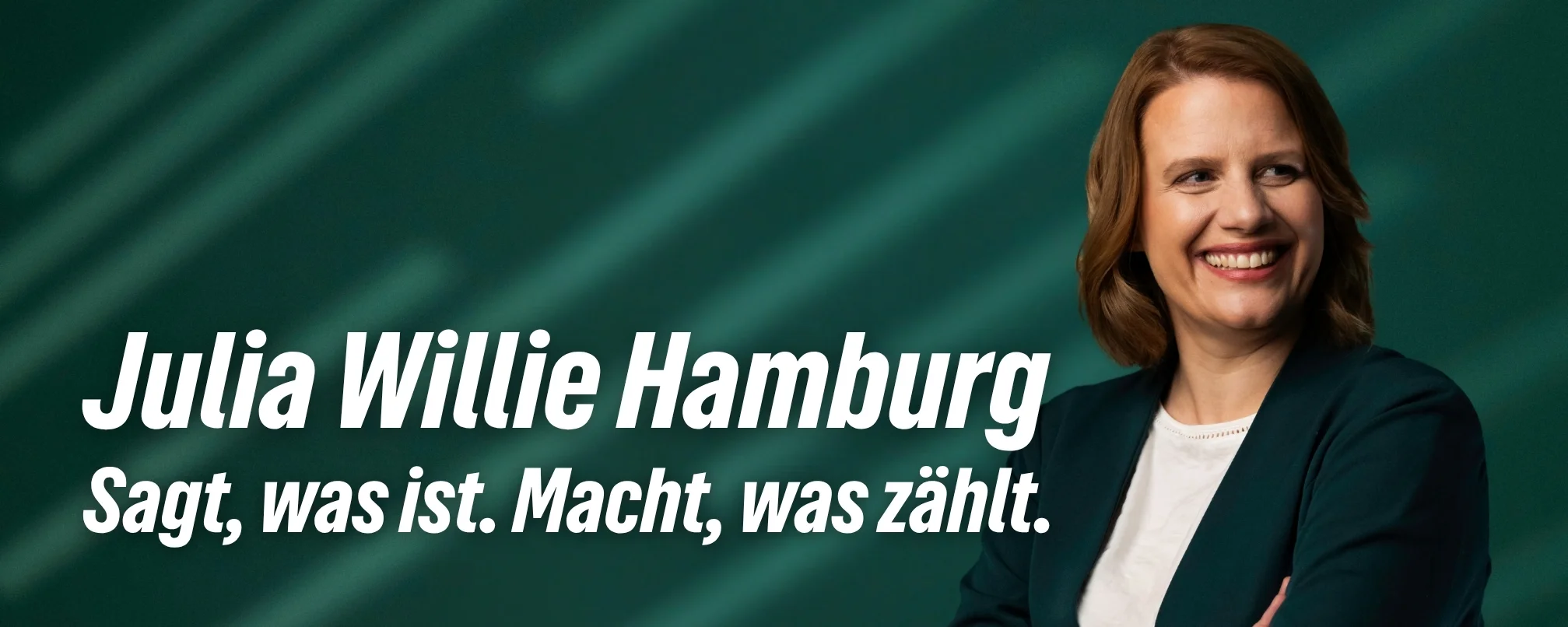 Greta Garlichs, Max Strautmann und Julia Willie Hamburg gehen mit Wahlplakaten unterm Arm über einen Zebrastreifen